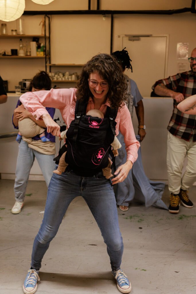 Une femme danse avec un bébé en portage