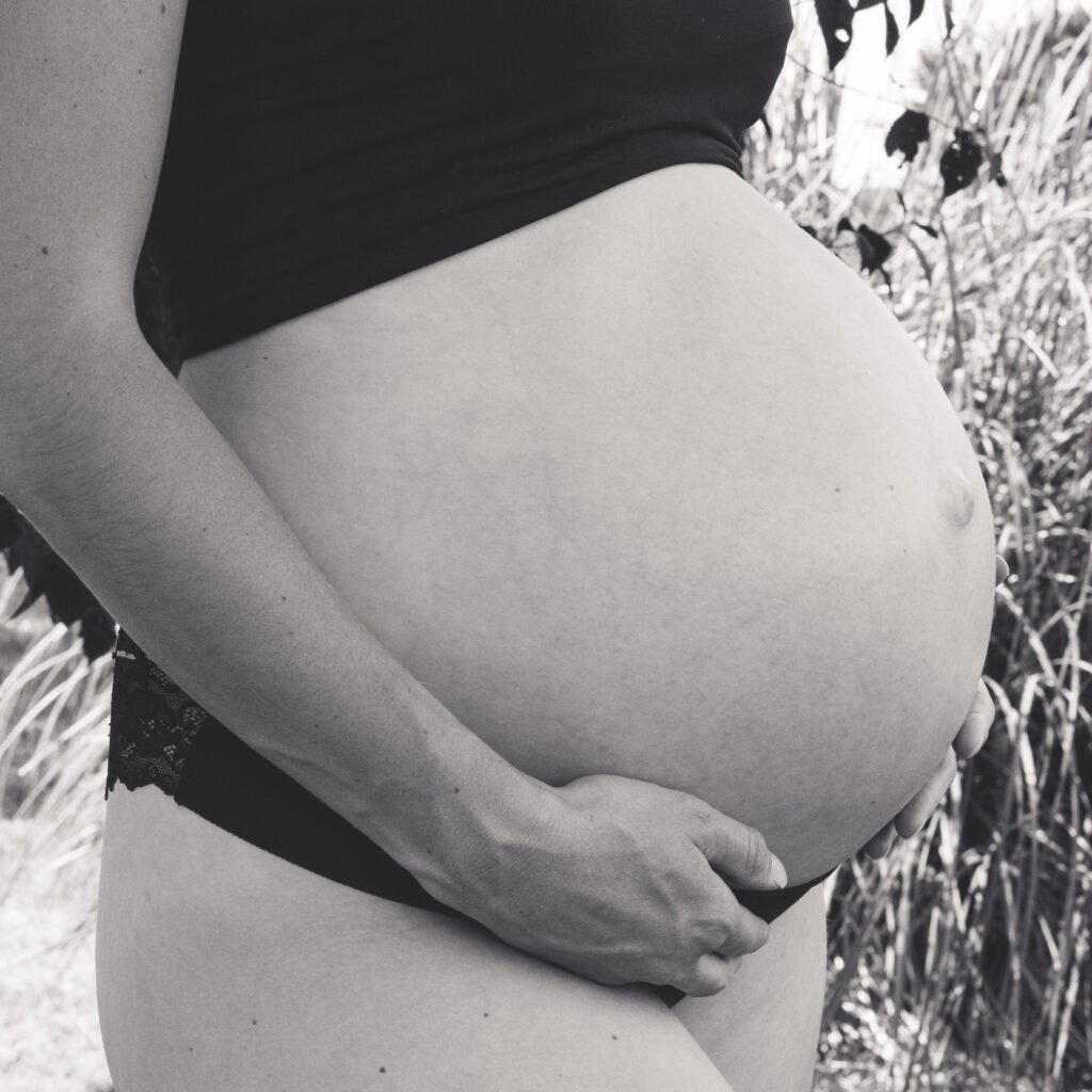 une femme enceinte qui a les mains sur son ventre